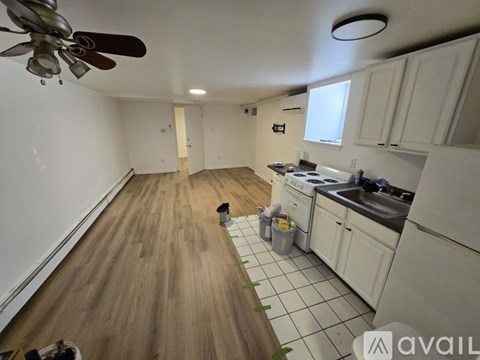 A kitchen with white cabinets and a wooden floor.