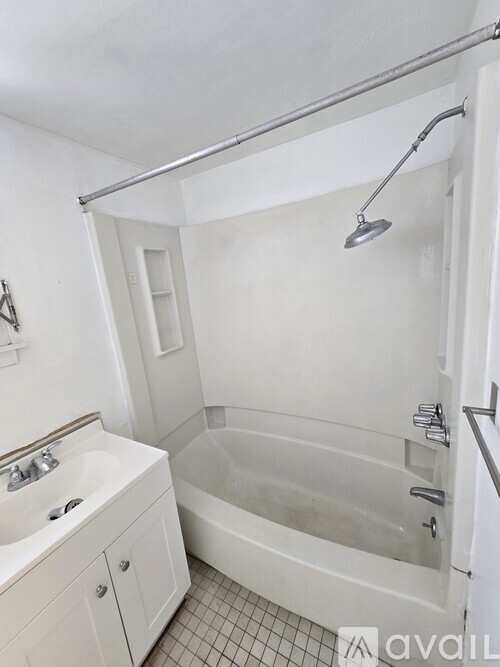 A white bathroom with a tub and sink.