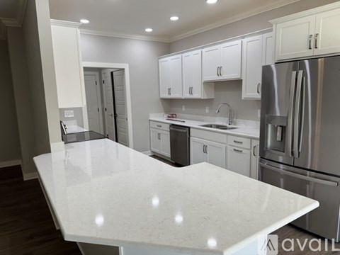 A kitchen with white cabinets and a marble countertop.