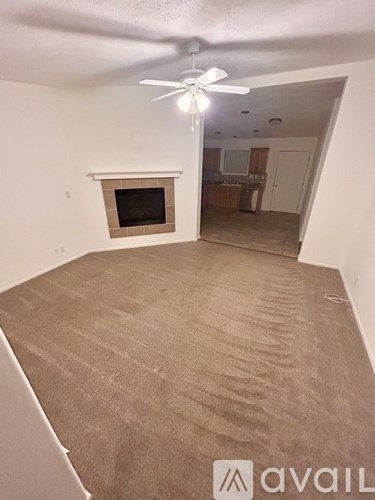 A room with a carpeted floor and a fireplace.