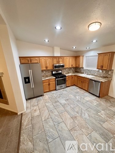 A kitchen with wooden cabinets and a stone countertop.