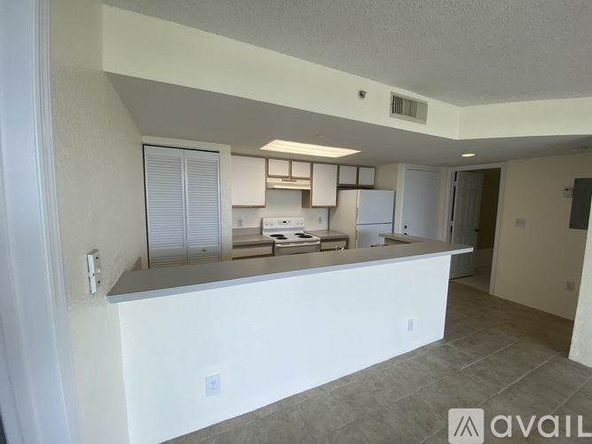 A kitchen area with a counter and cabinets is available for rent.
