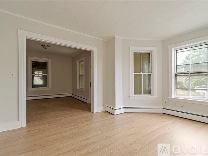 A room with a window and a door leading to another room.