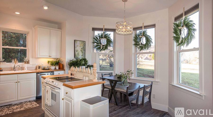 A kitchen with white cabinets and a wooden island.