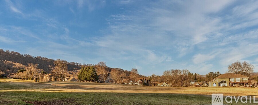 A house is available for sale in a rural setting with a field and trees in the background.