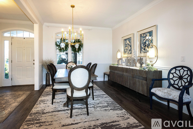 A dining room with a wooden table and chairs.