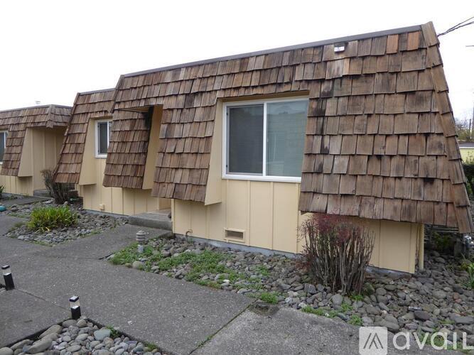 A row of houses with brown shingle roofs.