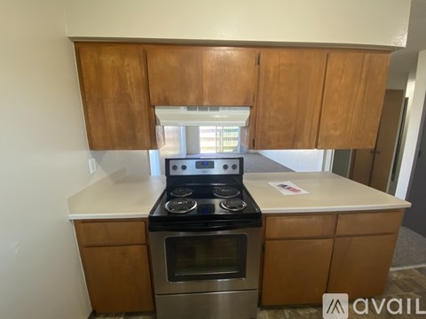 A kitchen with wooden cabinets and a black stove top oven.