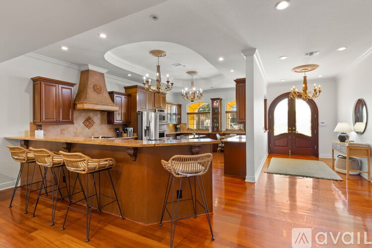 A kitchen with wooden cabinets and a bar area with stools.