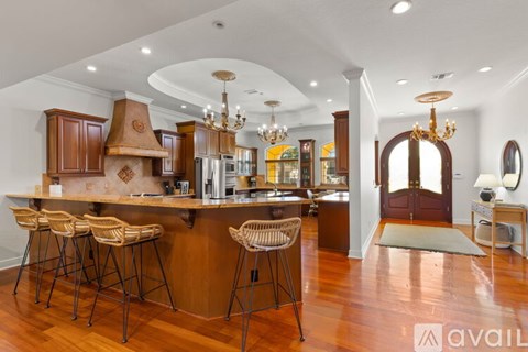 A kitchen with wooden cabinets and a bar area with stools.
