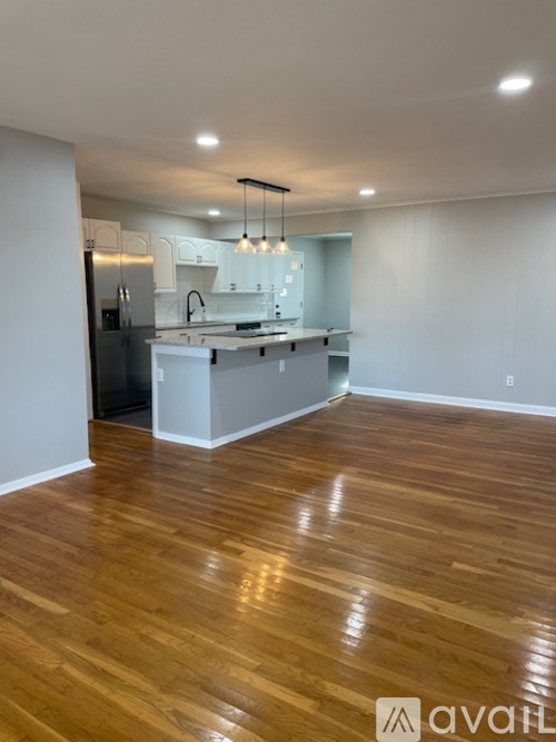 A kitchen with wooden floors and a refrigerator.