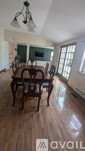 A dining room with a wooden table and chairs.