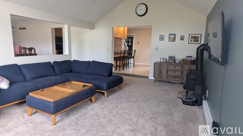A living room with a blue sofa and a wooden coffee table.