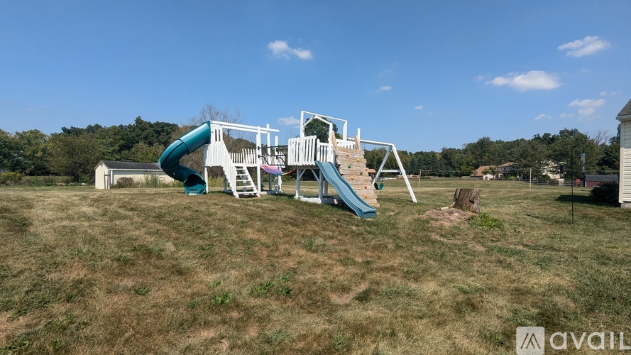 A playground with a blue slide and white structure.