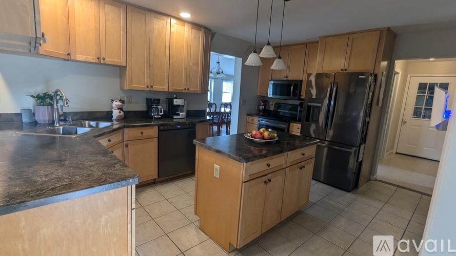 A kitchen with wooden cabinets and a granite countertop.