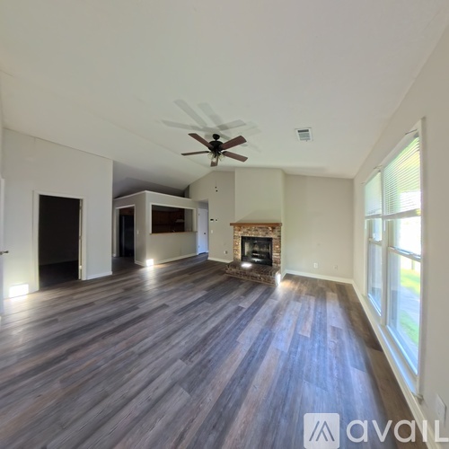 A room with a fireplace and wood flooring.