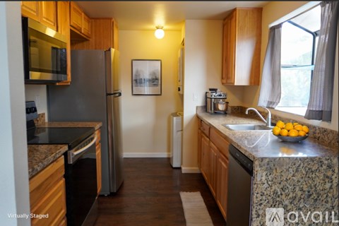 A kitchen with wooden cabinets and granite countertops.
