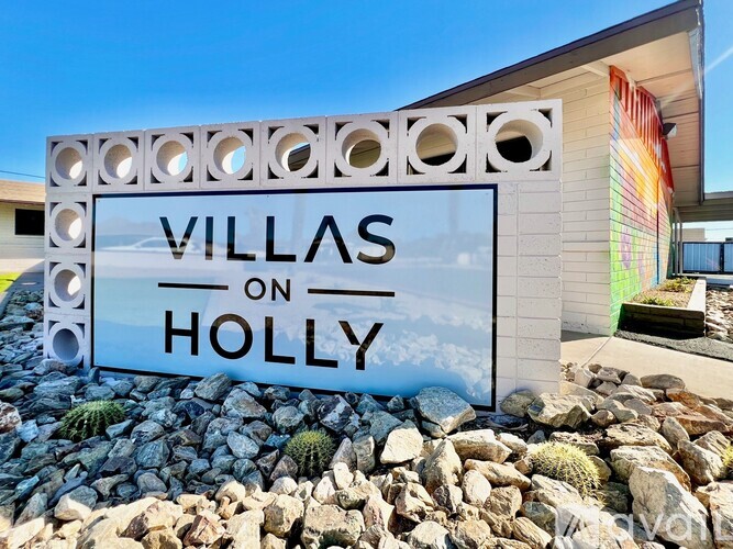 A sign that says Villas on Holly in front of a building.