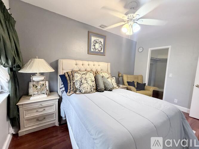 A bedroom with a large bed and a ceiling fan.