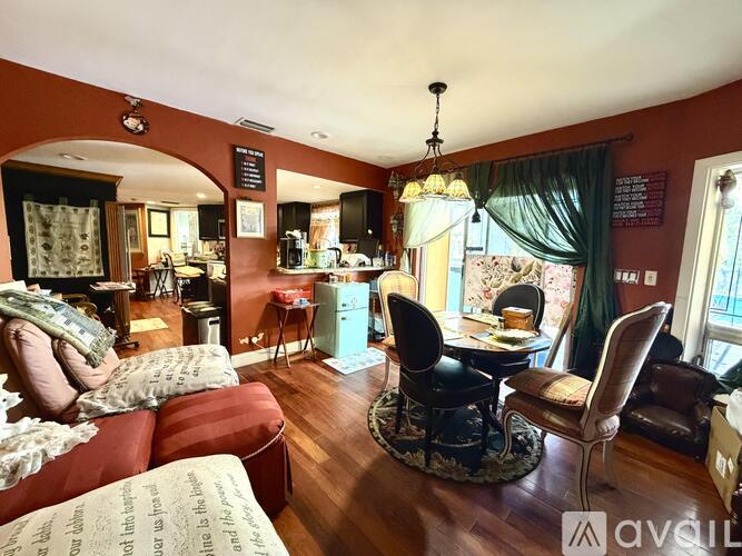 A living room with a couch, chairs, and a dining table.