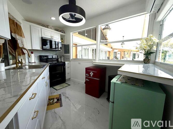 A kitchen with white cabinets and a marble countertop.