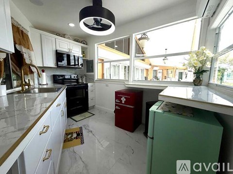 A kitchen with white cabinets and a marble countertop.