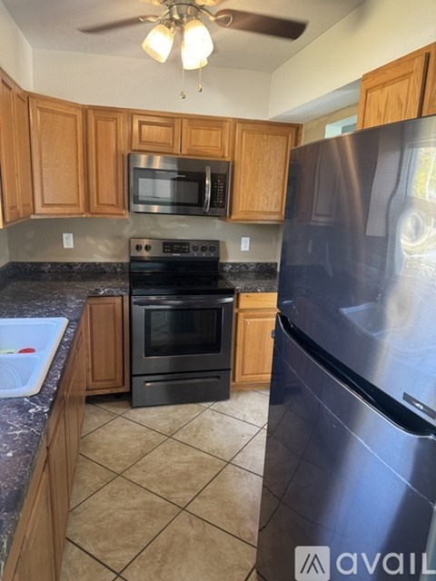A kitchen with wooden cabinets and a stainless steel refrigerator.