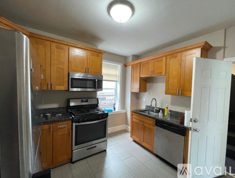 A kitchen with wooden cabinets and black countertops.