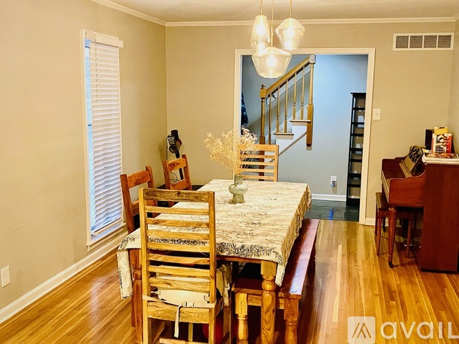 A dining room with a wooden table and chairs.
