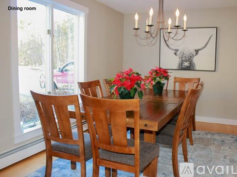 A dining room with a wooden table and chairs.