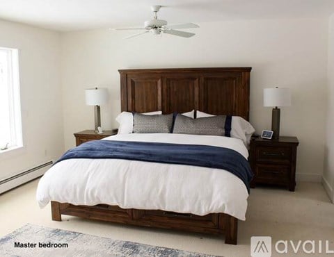 A bedroom with a large bed and a ceiling fan.