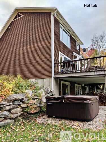 A hot tub is placed in front of a house.