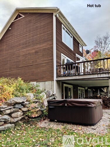A hot tub is placed in front of a house.