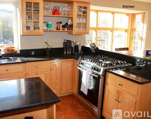 A kitchen with wooden cabinets and a black countertop.