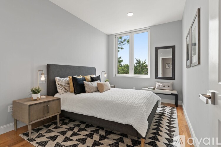 A bedroom with a large bed and a window overlooking the trees.