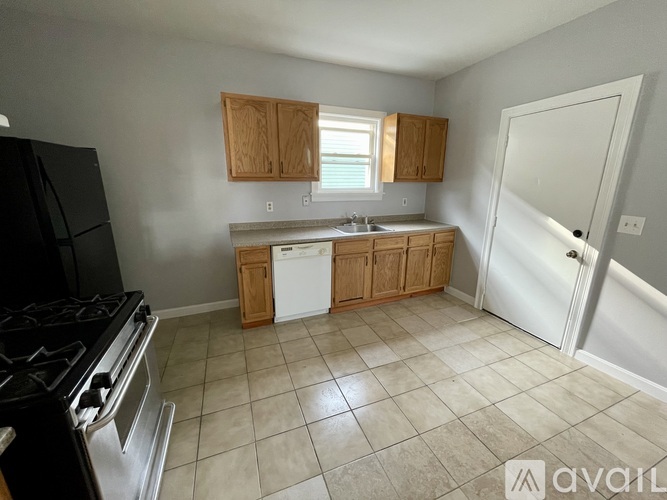 A kitchen with a black stove top oven and white dishwasher.