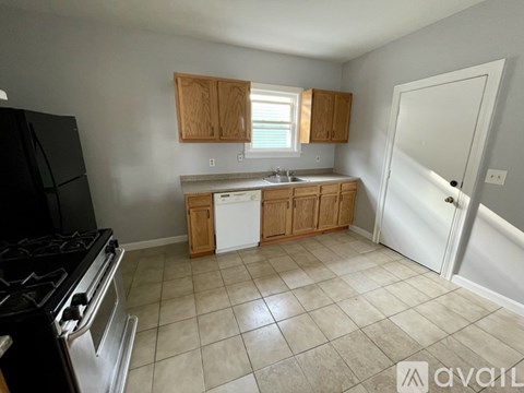A kitchen with a black stove top oven and white dishwasher.