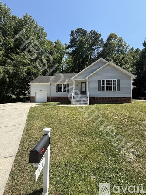 A house with a white fence and a mailbox in front.