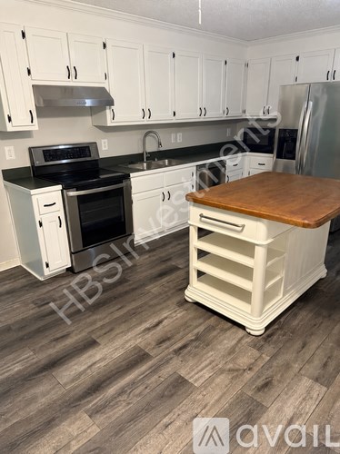 A kitchen with a black stove top oven and a white refrigerator.