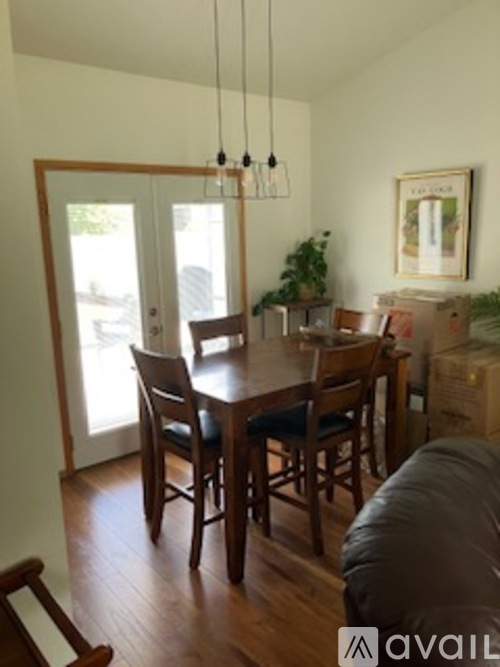 A dining room with a wooden table and chairs.