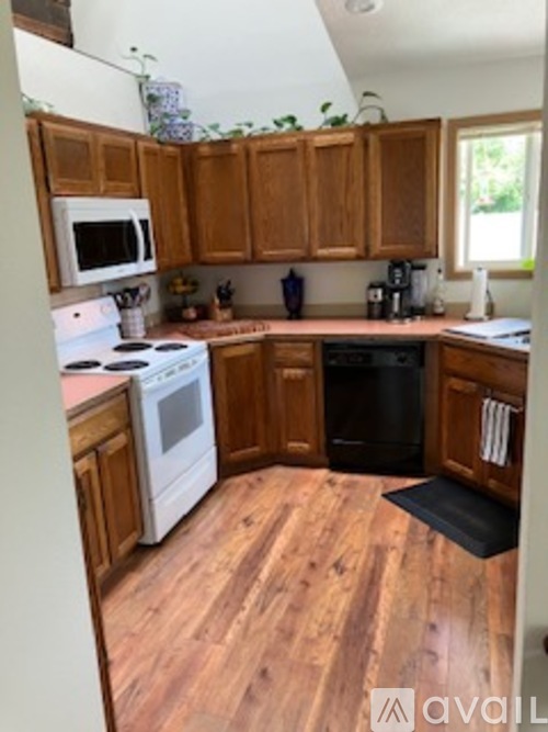 A kitchen with wooden cabinets and a white stove top oven.