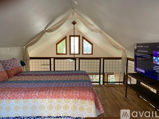 A bedroom with two beds and a television on the wall.