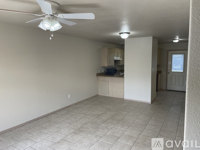 A room with a ceiling fan and tiled flooring.