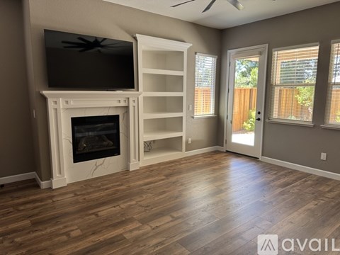 A living room with a fireplace and a television on the wall.