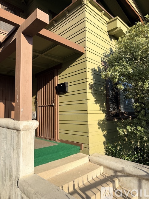 A house with a green door mat and a brown railing.