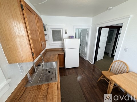 A kitchen with wooden cabinets and a white fridge.
