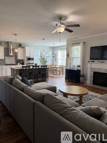 A living room with a long couch and a ceiling fan.