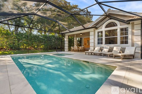 A pool in a backyard with a house in the background.