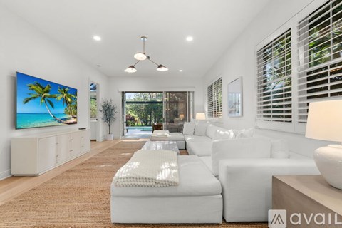 A living room with a large television and a white sofa.