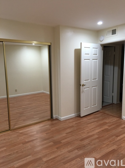 A room with a wooden floor and a white door.
